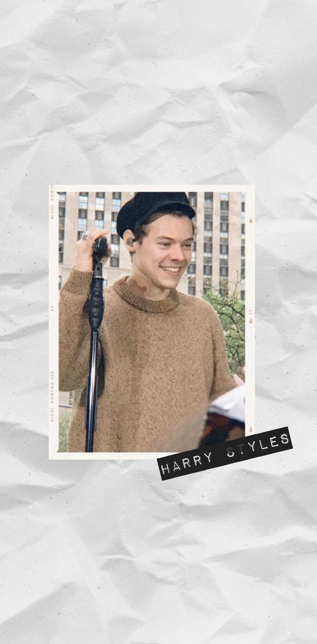 A man is holding an umbrella and smiling - Harry Styles