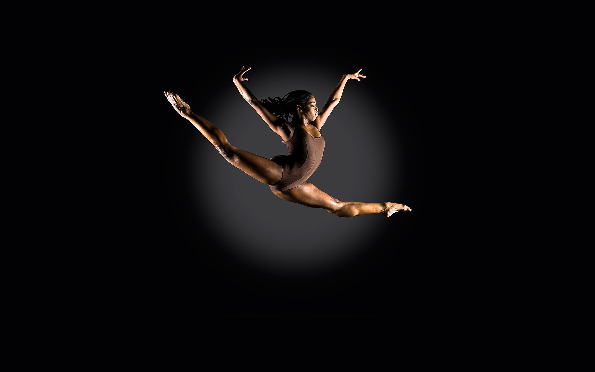 A woman in black leotard is jumping - Gymnastics