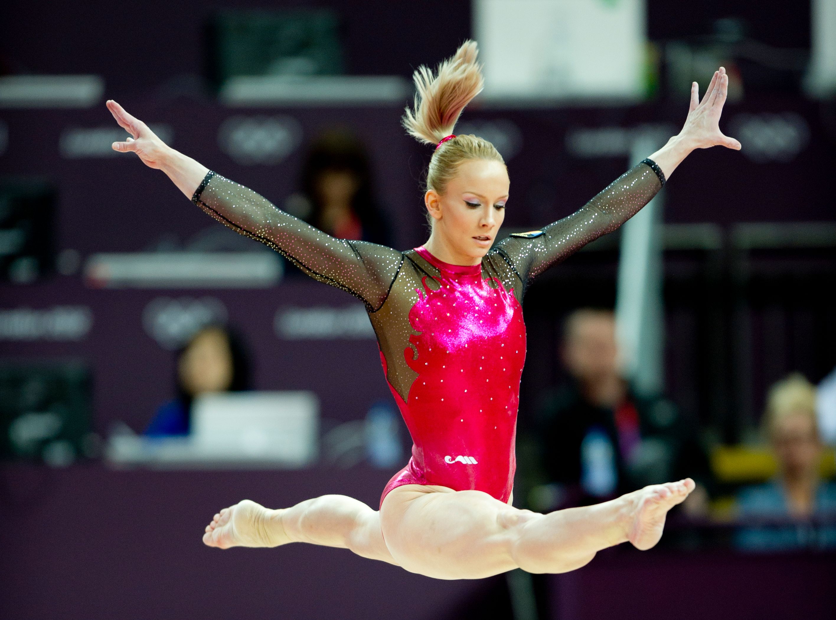 A gymnast performing a split on the balance beam - Gymnastics