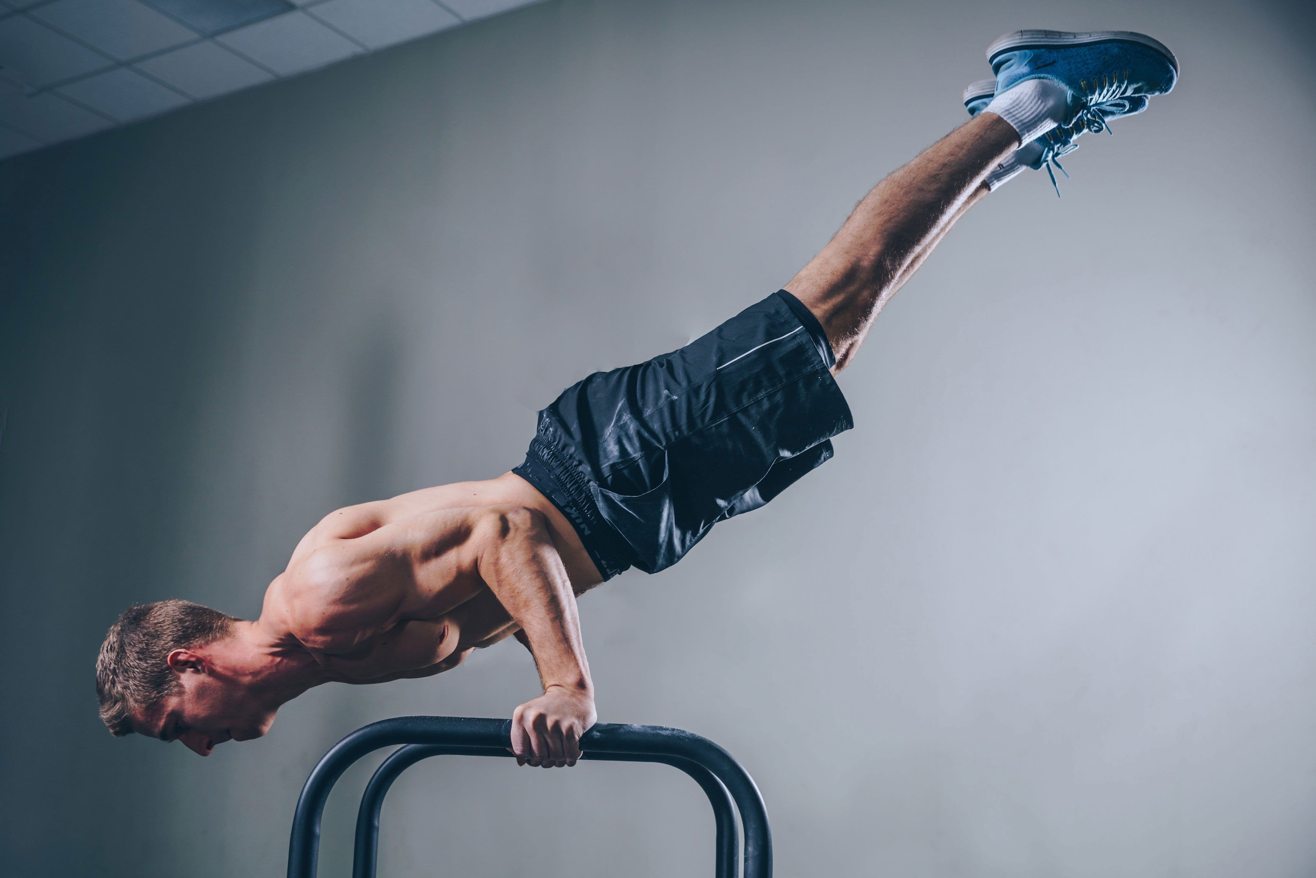 Man doing push ups on a bar - Gymnastics