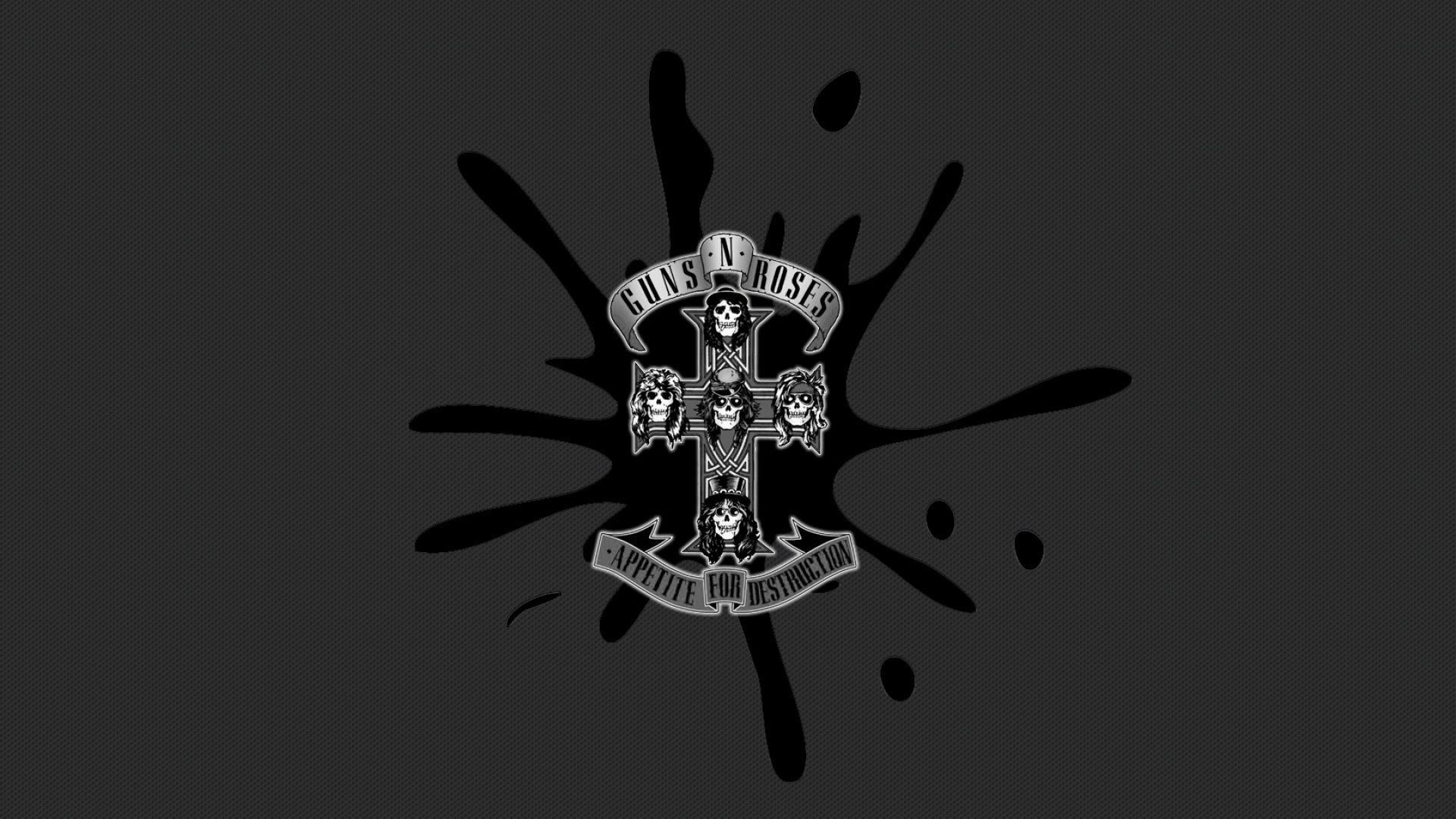 A Guns N' Roses wallpaper featuring the band's logo with skulls and a cross, with a black paint splatter design. - Cross