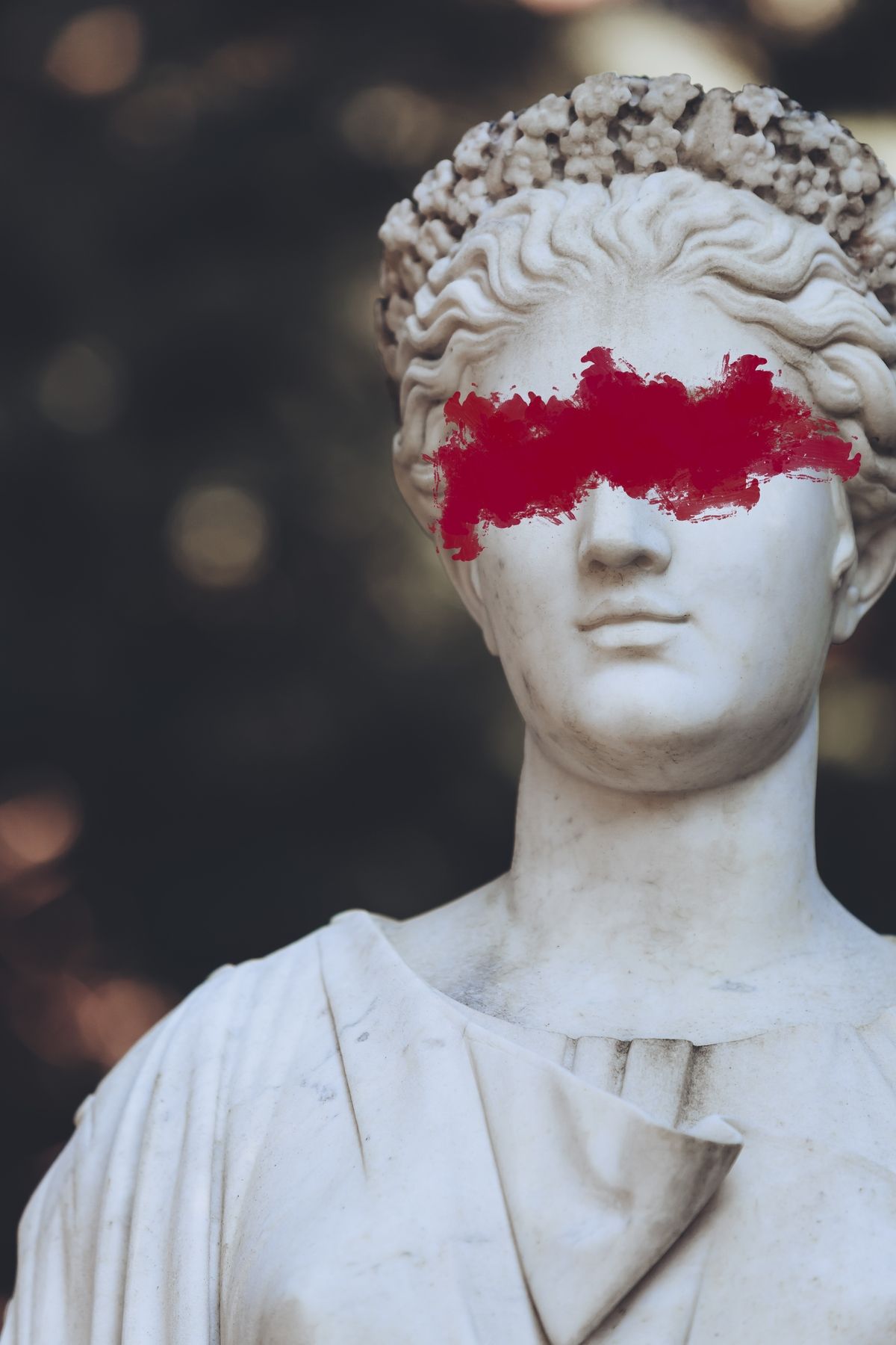 A statue with red paint over its eyes. - Greek statue