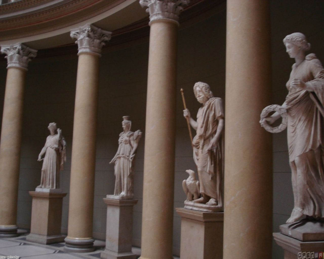 A row of columns with statues of women on top. - Greek statue