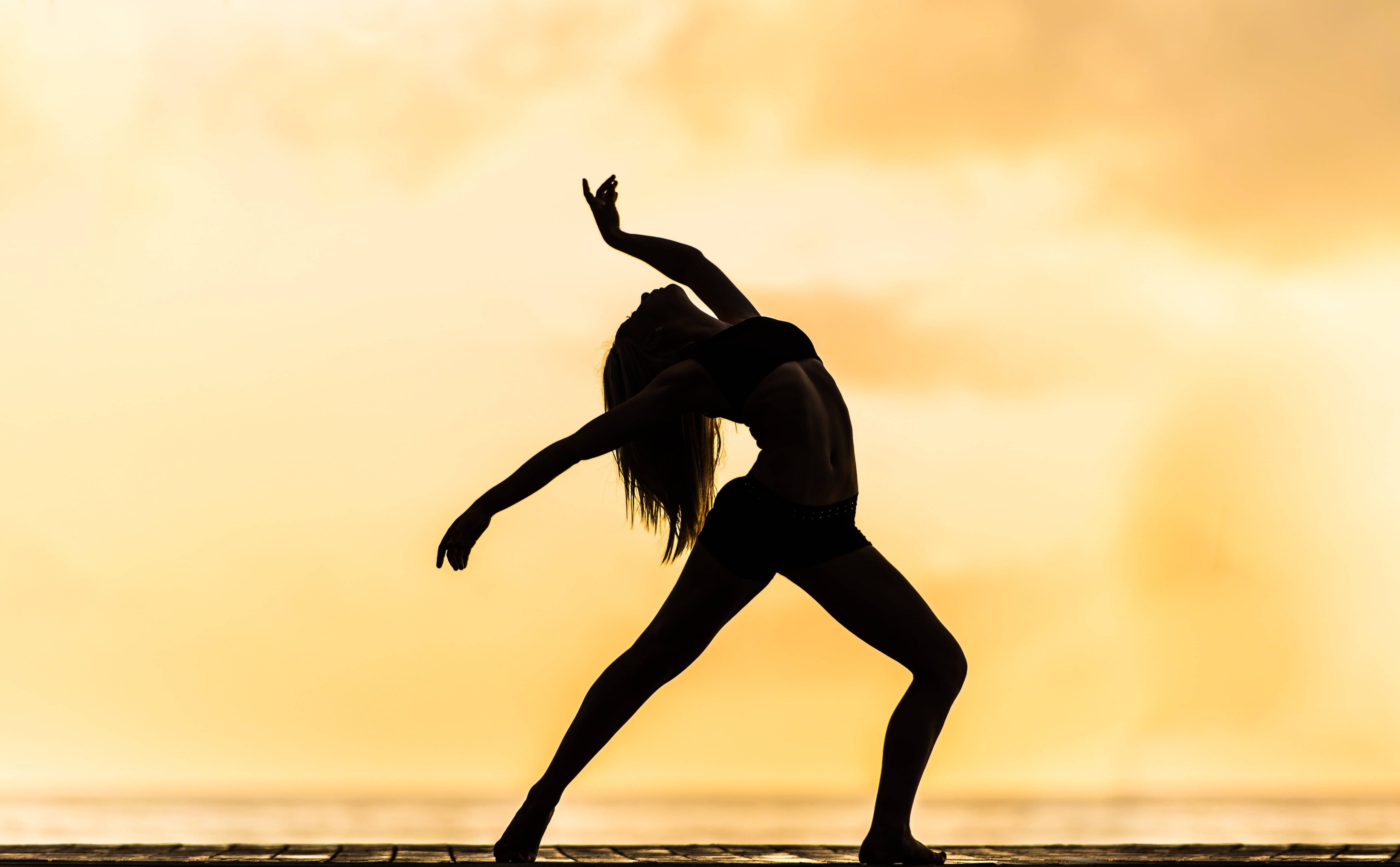 A woman is doing yoga on the beach - Dance