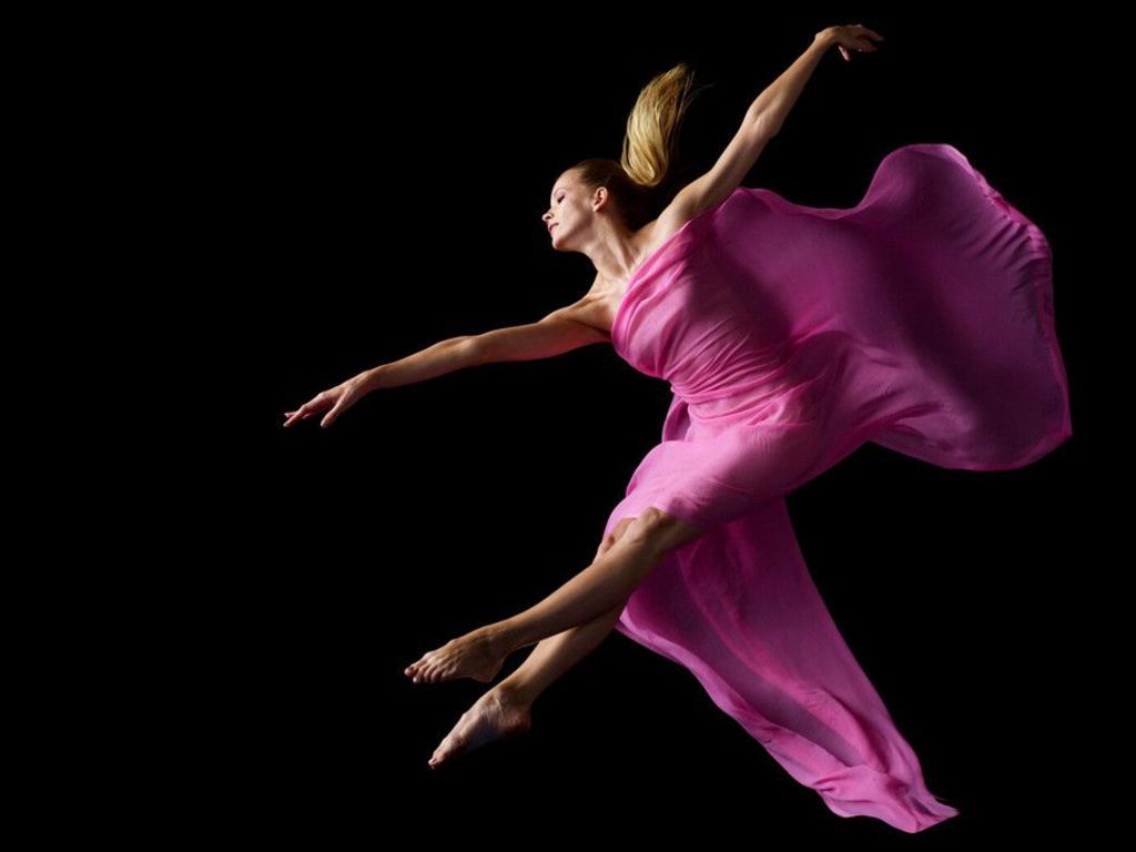 A woman in pink is jumping through the air - Dance