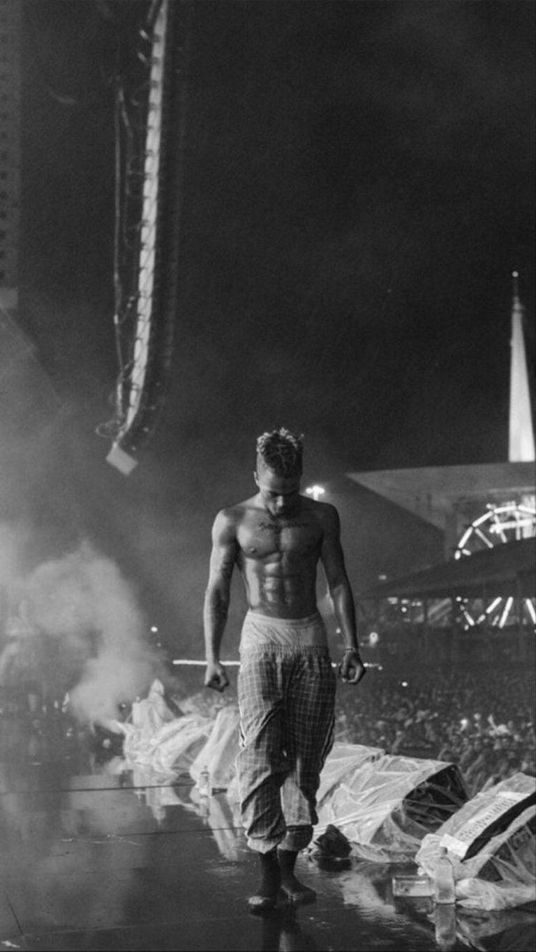 A man walking on stage at night - XXXTentacion