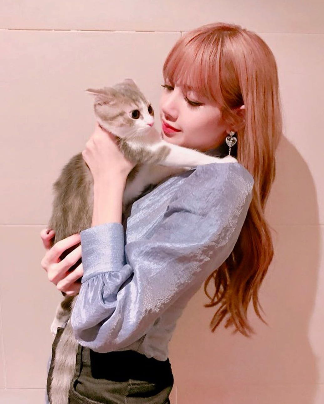 A woman holding up her cat in front of the camera - Cat, BLACKPINK