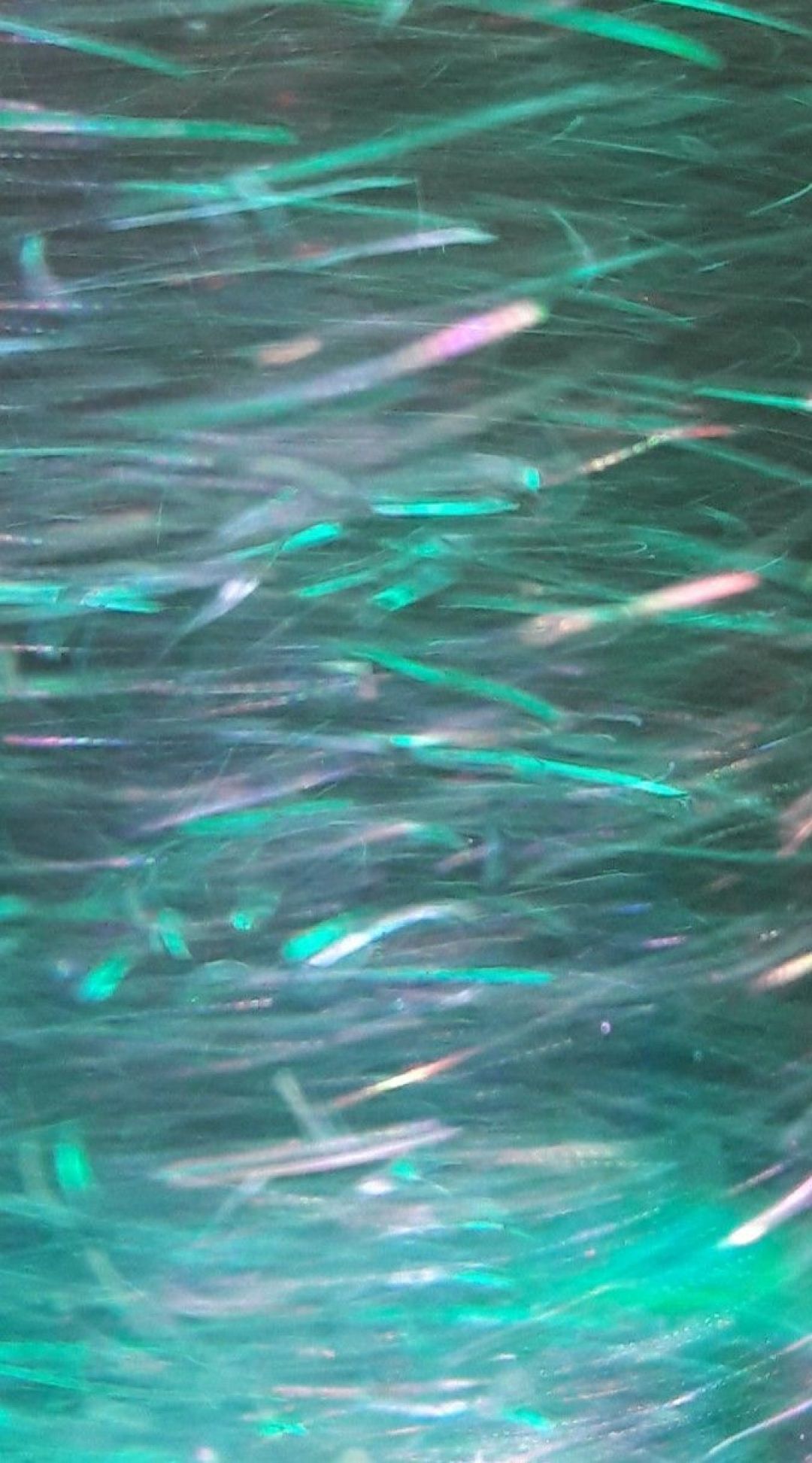A close up of a shiny, iridescent material with a green tint - Mint green