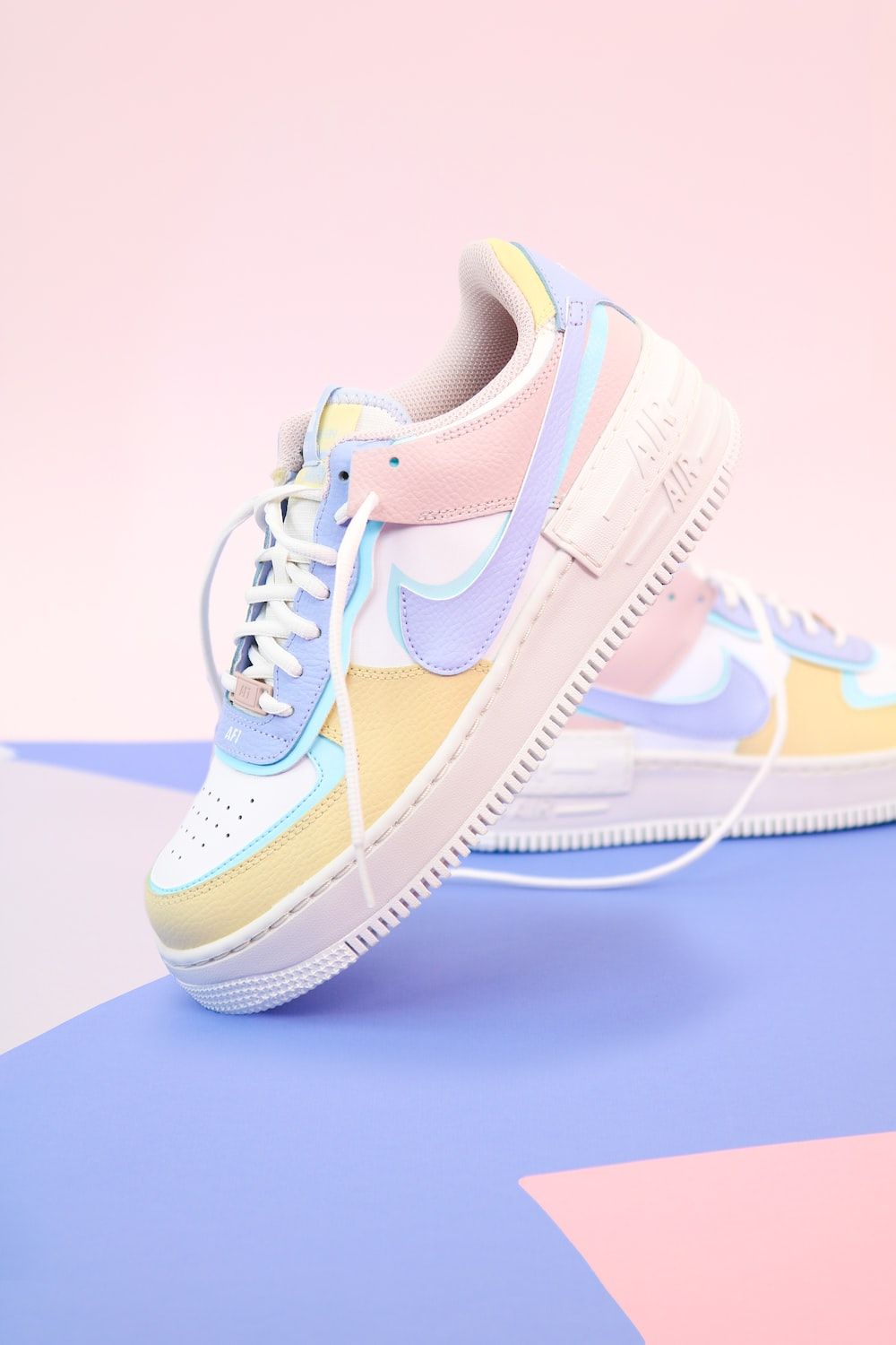 A pair of pastel Nike Air Force 1 Shadow sneakers on a pastel background - Shoes