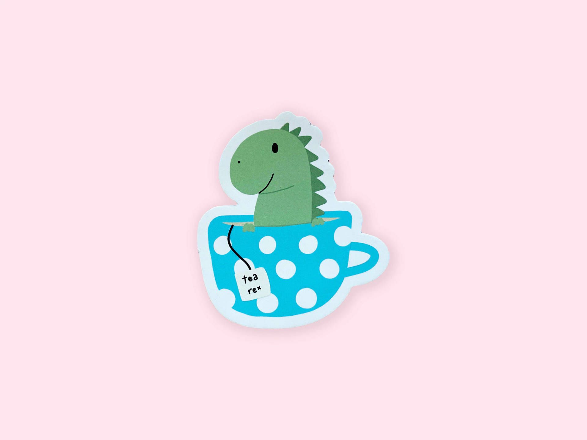 A sticker of a green dinosaur in a blue polka dot teacup. - Dinosaur