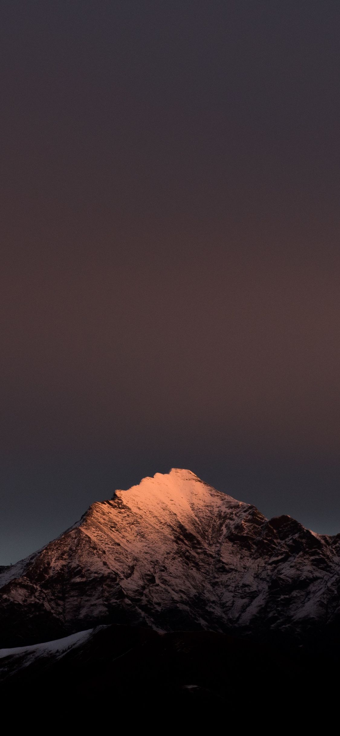 A mountain with snow on it at night - Clean