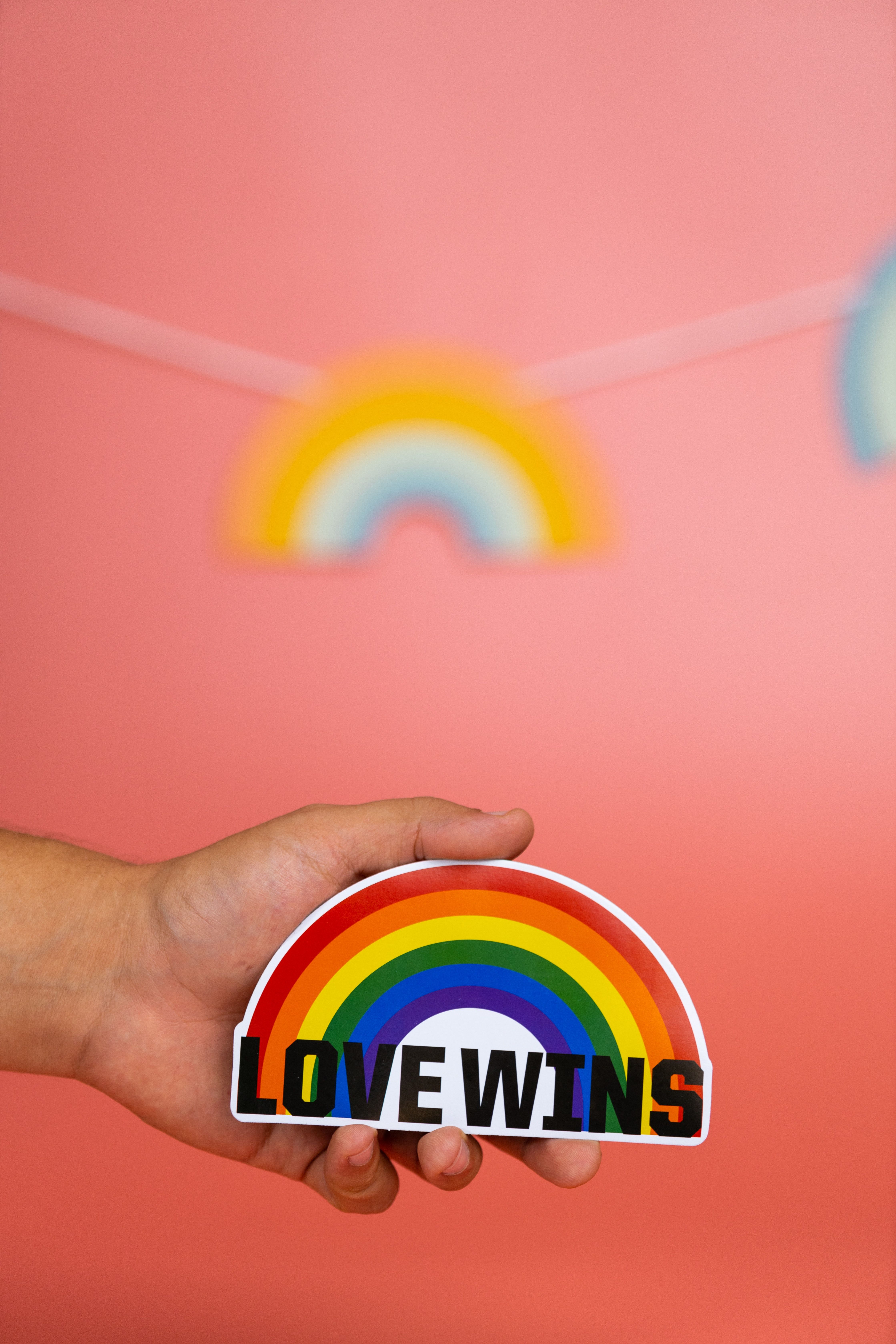 A person holding up an lgbtq rainbow flag - Gay, pride, LGBT