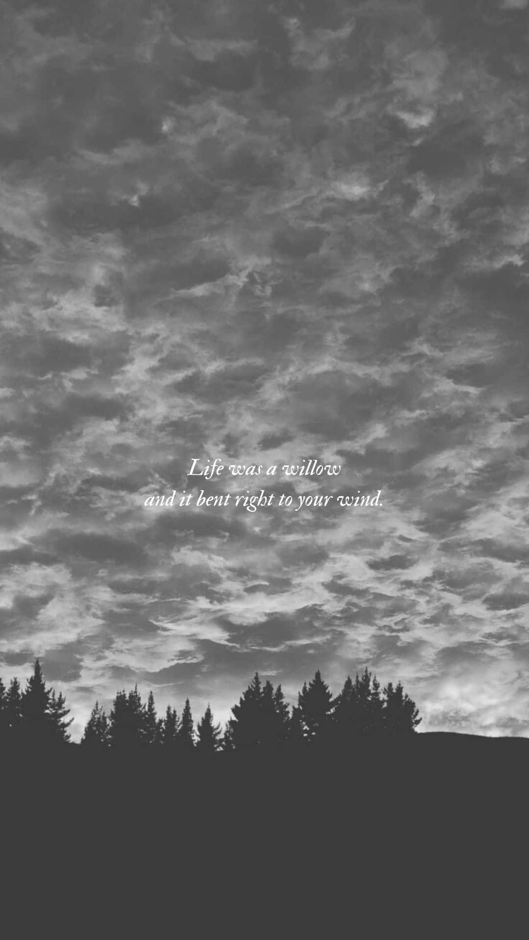 A black and white photo of a cloudy sky with a row of trees at the bottom. The sky has a quote in the middle that says 