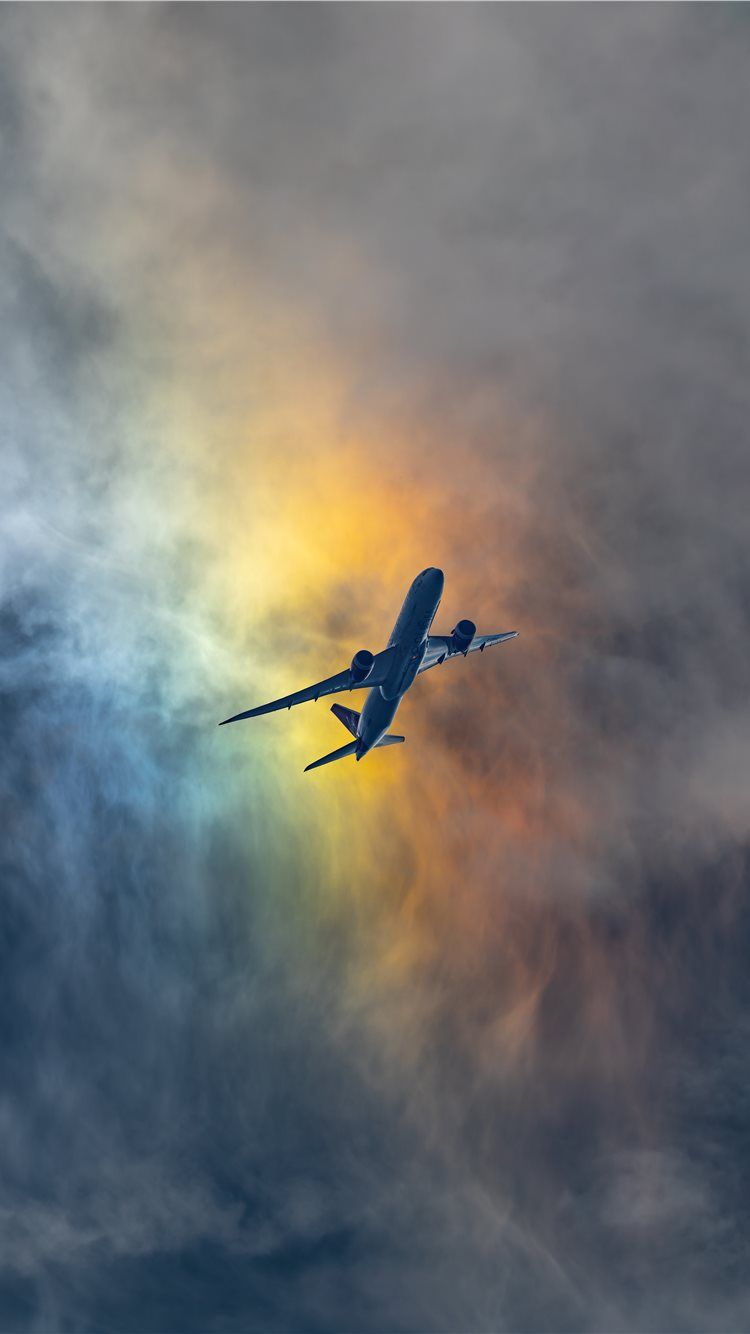 A plane flying in the sky with clouds - Gay, travel