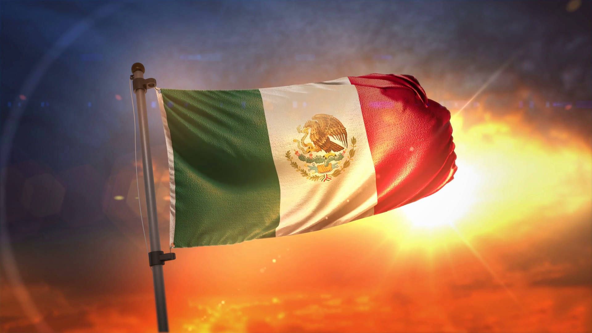 Mexican flag waving in the wind against a beautiful sunset - Mexico