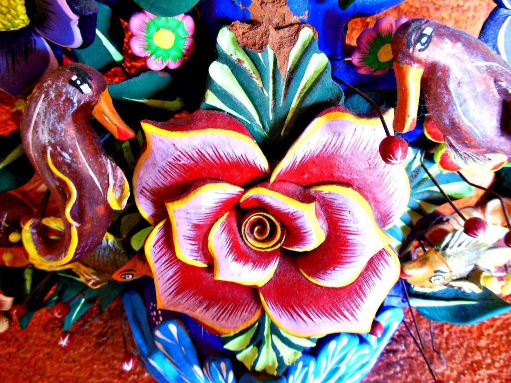 Colorful wooden flower with birds and flowers in the background - Mexico