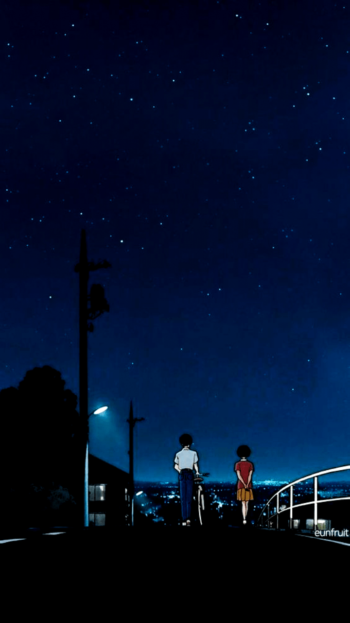 A couple of people walking down the street at night - Night