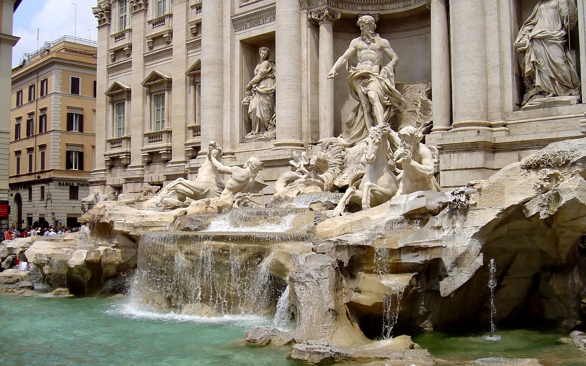 A fountain with statues and water in front of a building. - Italy