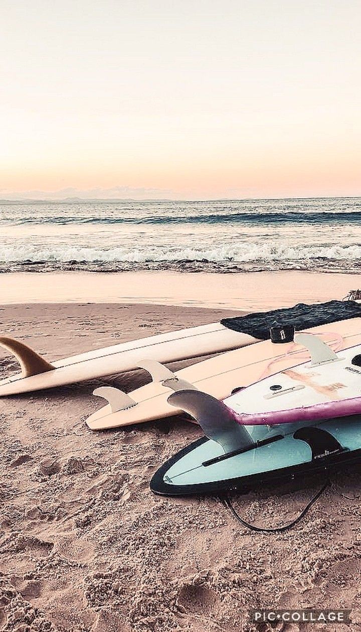 A couple of surfboards laying on the beach - Surf