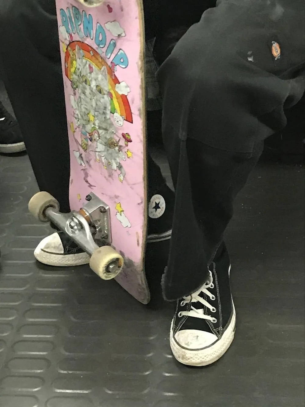 A person sitting down with a skateboard on their feet - Skate, skater