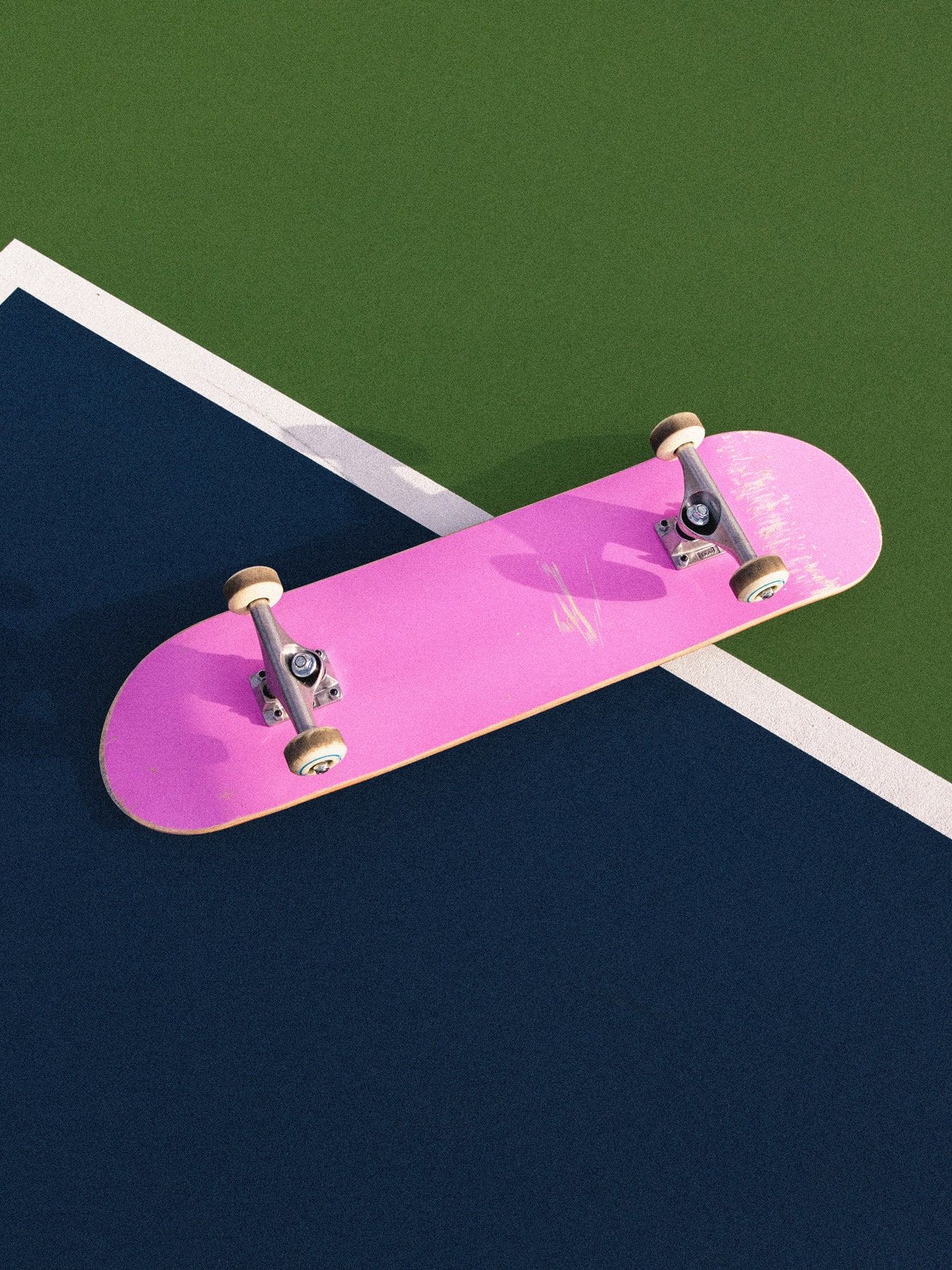 A pink skateboard on a tennis court - Skate