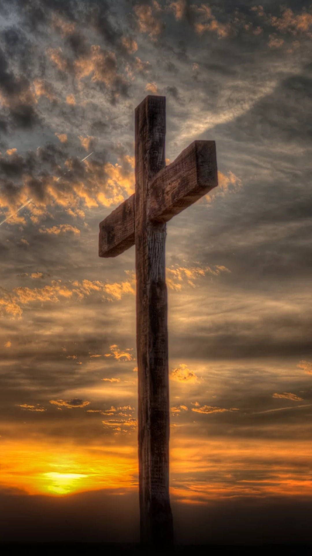 A cross is standing in front of the sunset - Cross