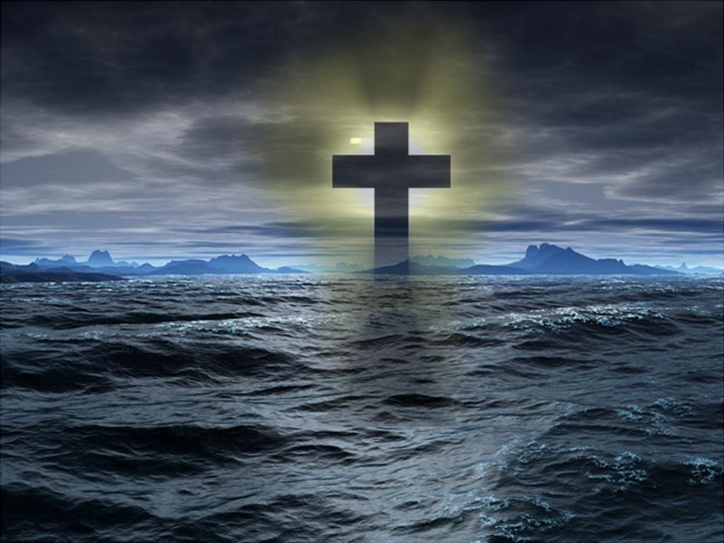 A cross on the water with the sun behind it - Cross