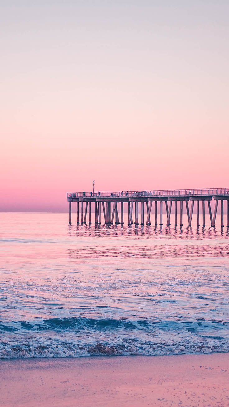 A pier on the ocean during a pink sunset - Rose gold