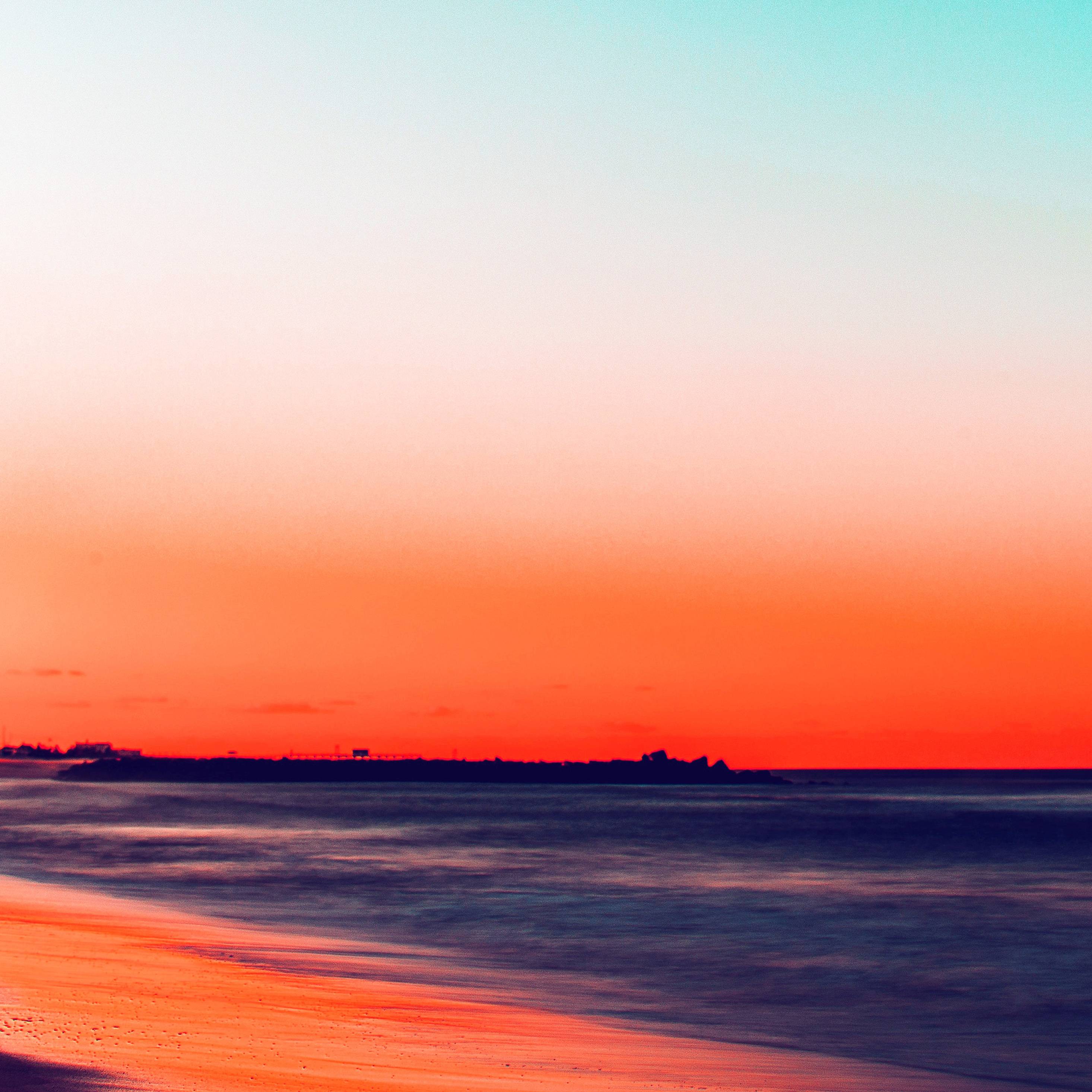 A photo of a sunset over the ocean with a gradient of red, orange, and blue. - Calming