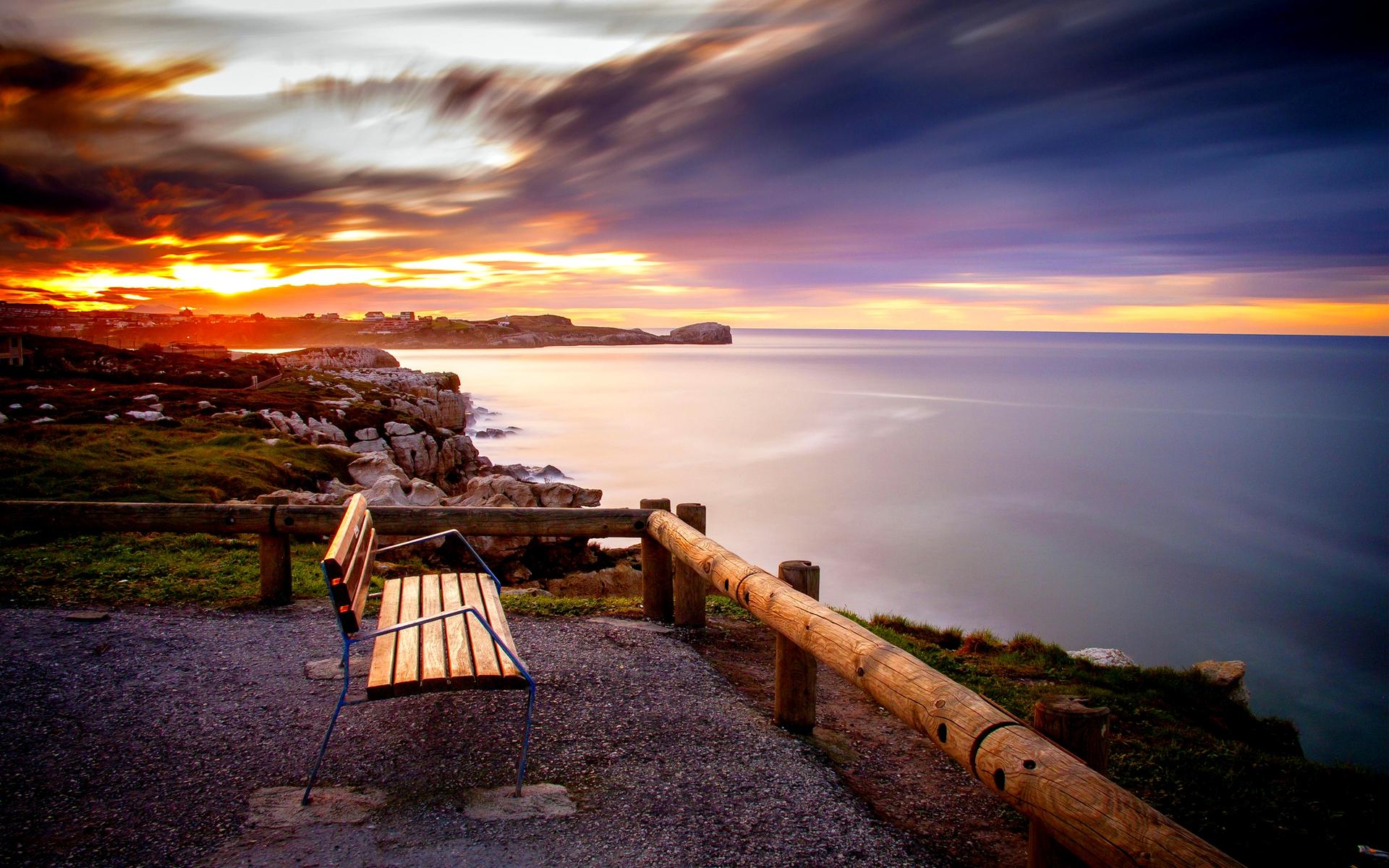 A bench overlooking the ocean at sunset. - Calming