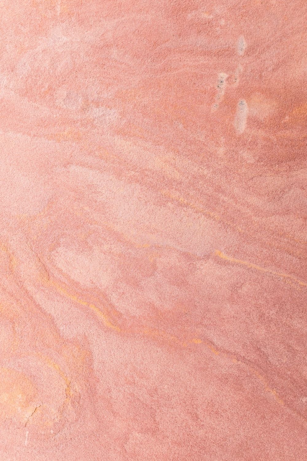 A pink marble background with a white bird on the bottom left - Gold, salmon, peach