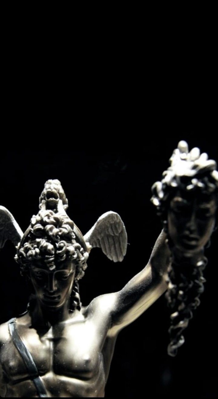 A statue of an angel holding a human head. - Greek statue