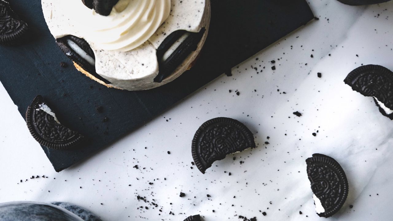 A cake with white frosting and oreo cookies - Oreo