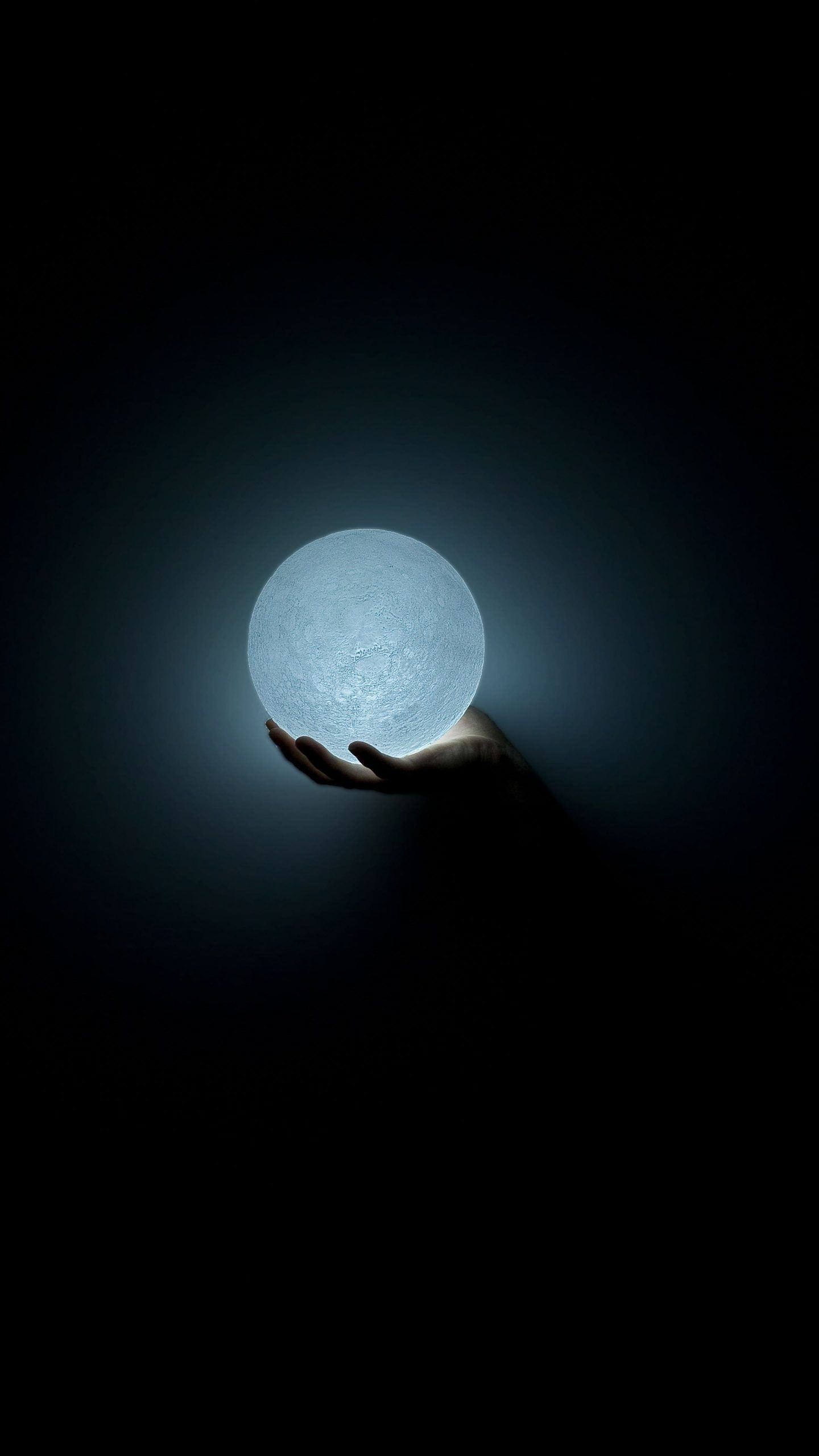 A hand holding up an illuminated ball - HD