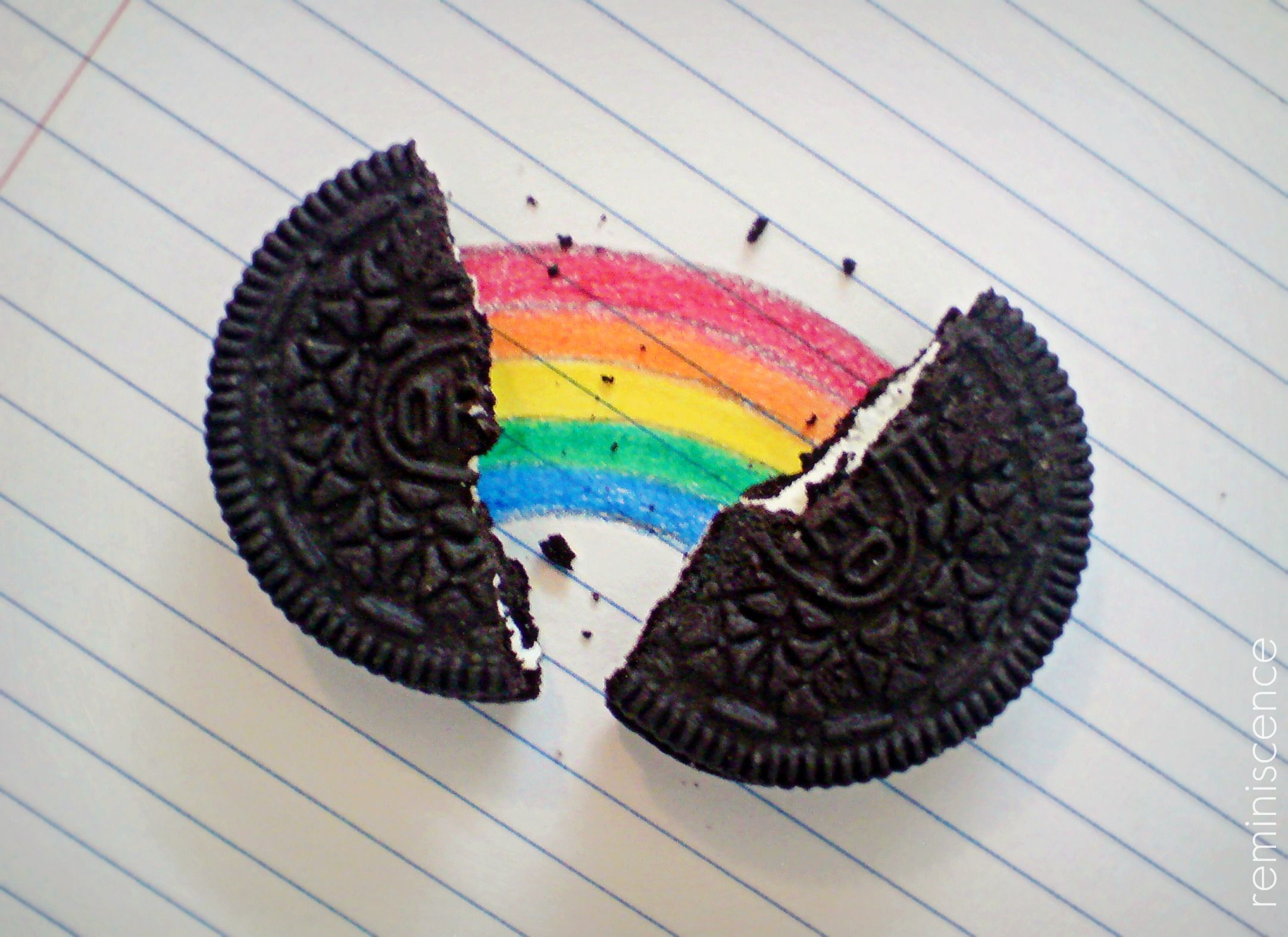 An Oreo cookie broken in half with a rainbow drawn on the inside - Oreo
