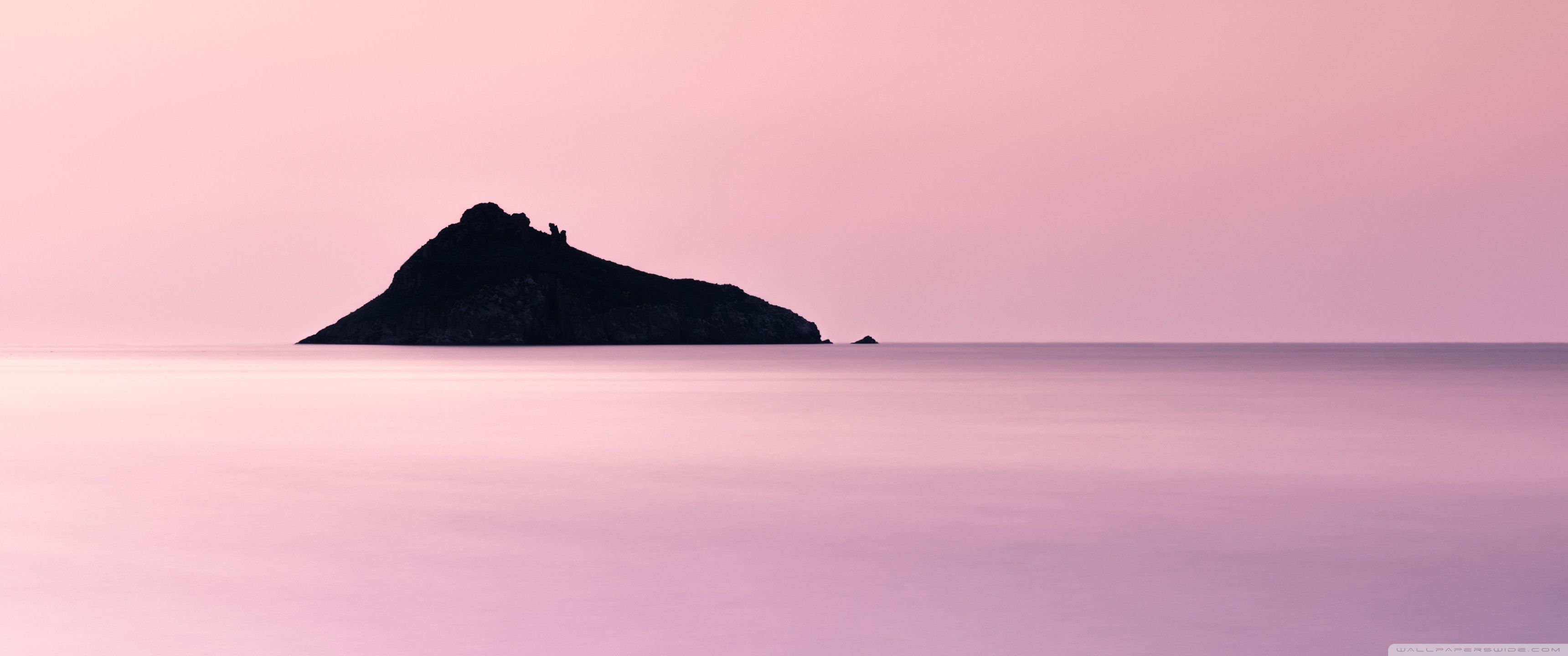 Island in the middle of the sea during sunset - 3440x1440