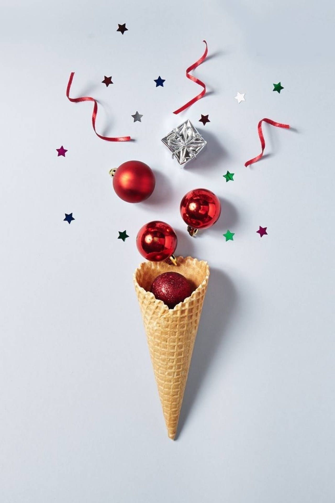 Red Christmas baubles, stars and a present in a waffle cone - Ice cream