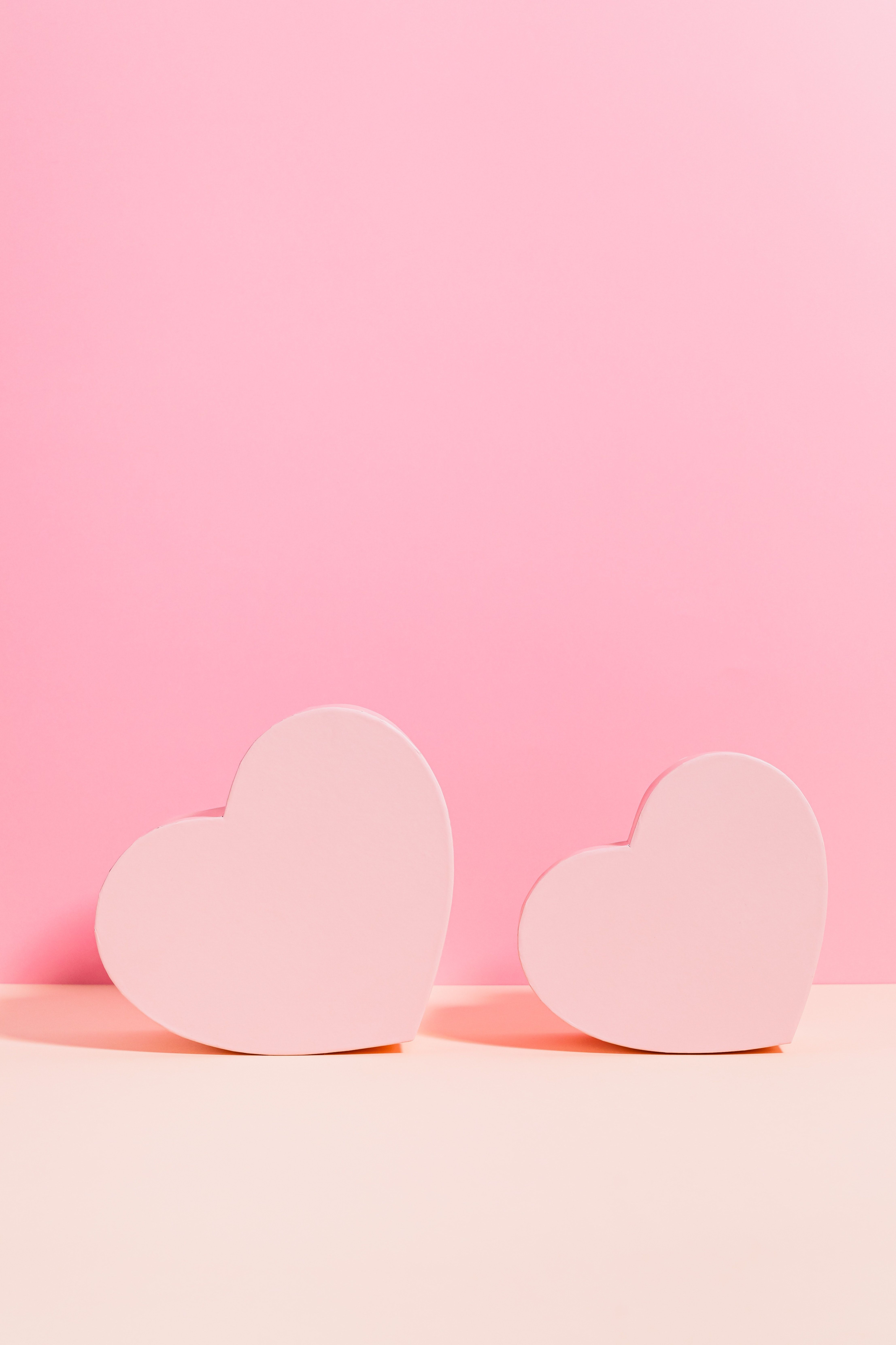 A photo of two pink hearts on a pink and beige background - Pink heart