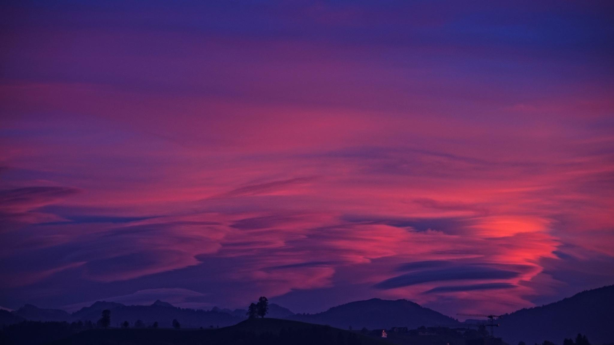 A purple and pink sunset over a mountain range - 2048x1152