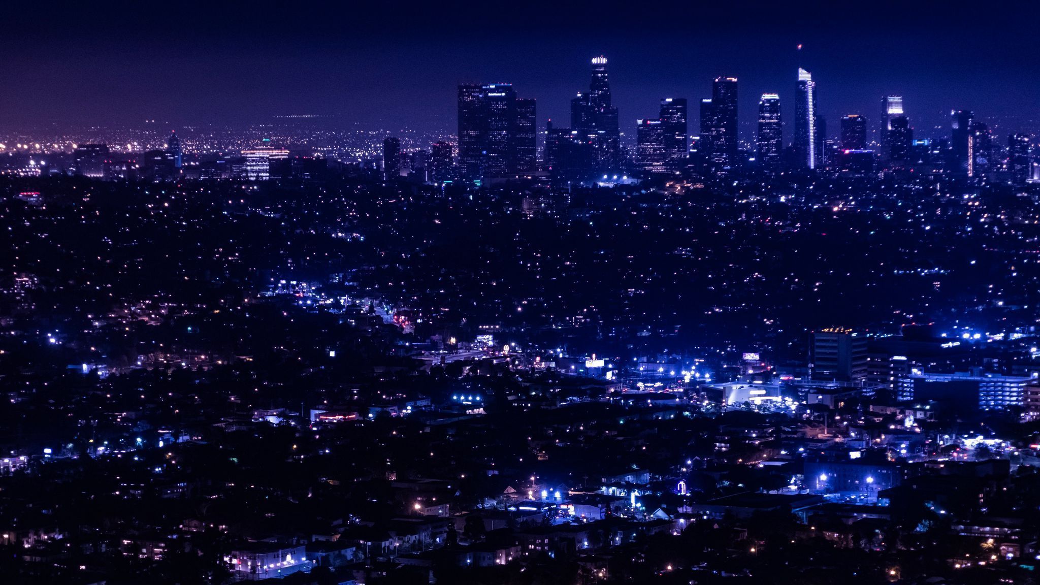 A city skyline at night with lights - 2048x1152