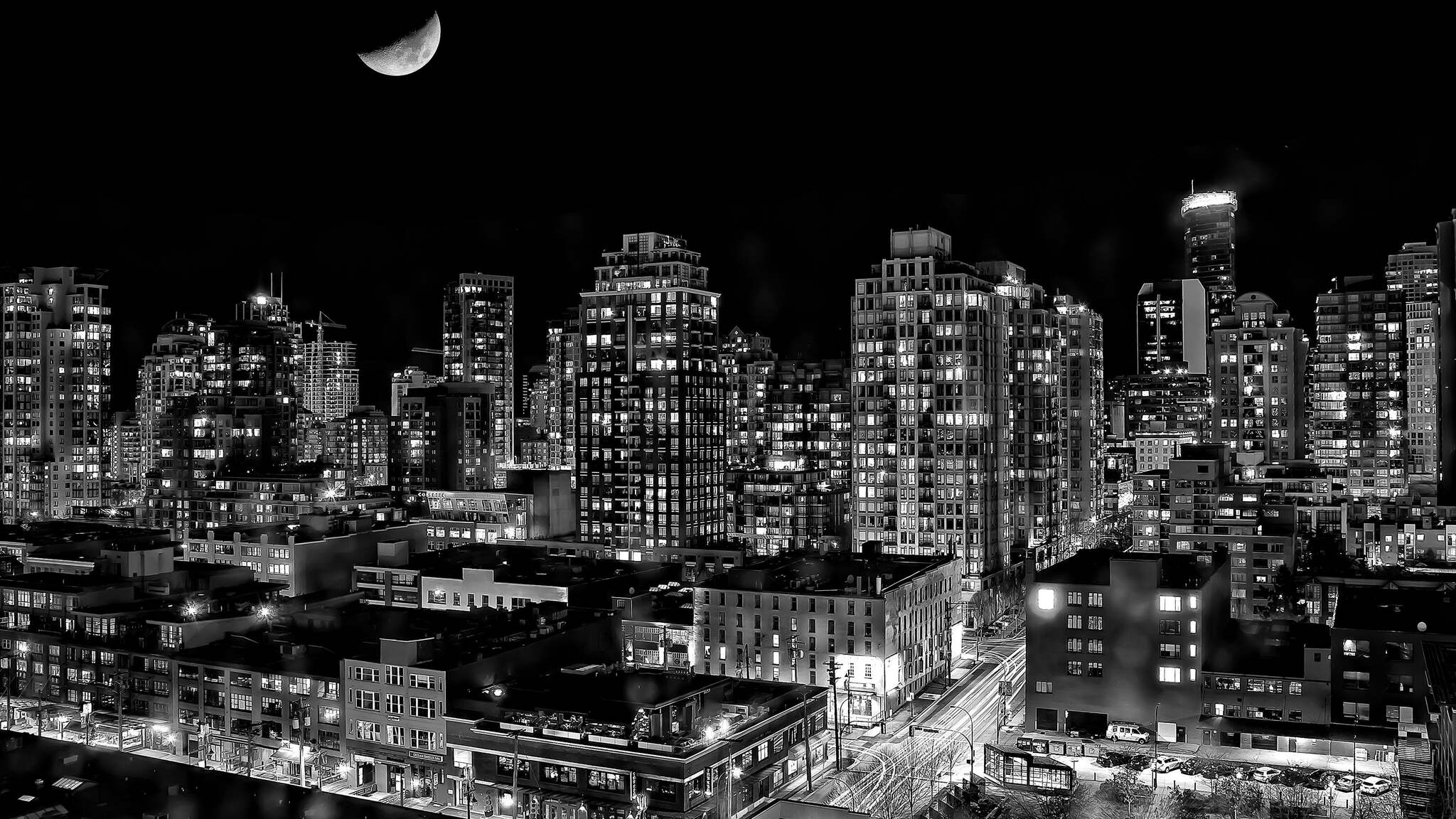 A black and white photo of a city at night with a half moon in the sky. - City, 2048x1152, black and white