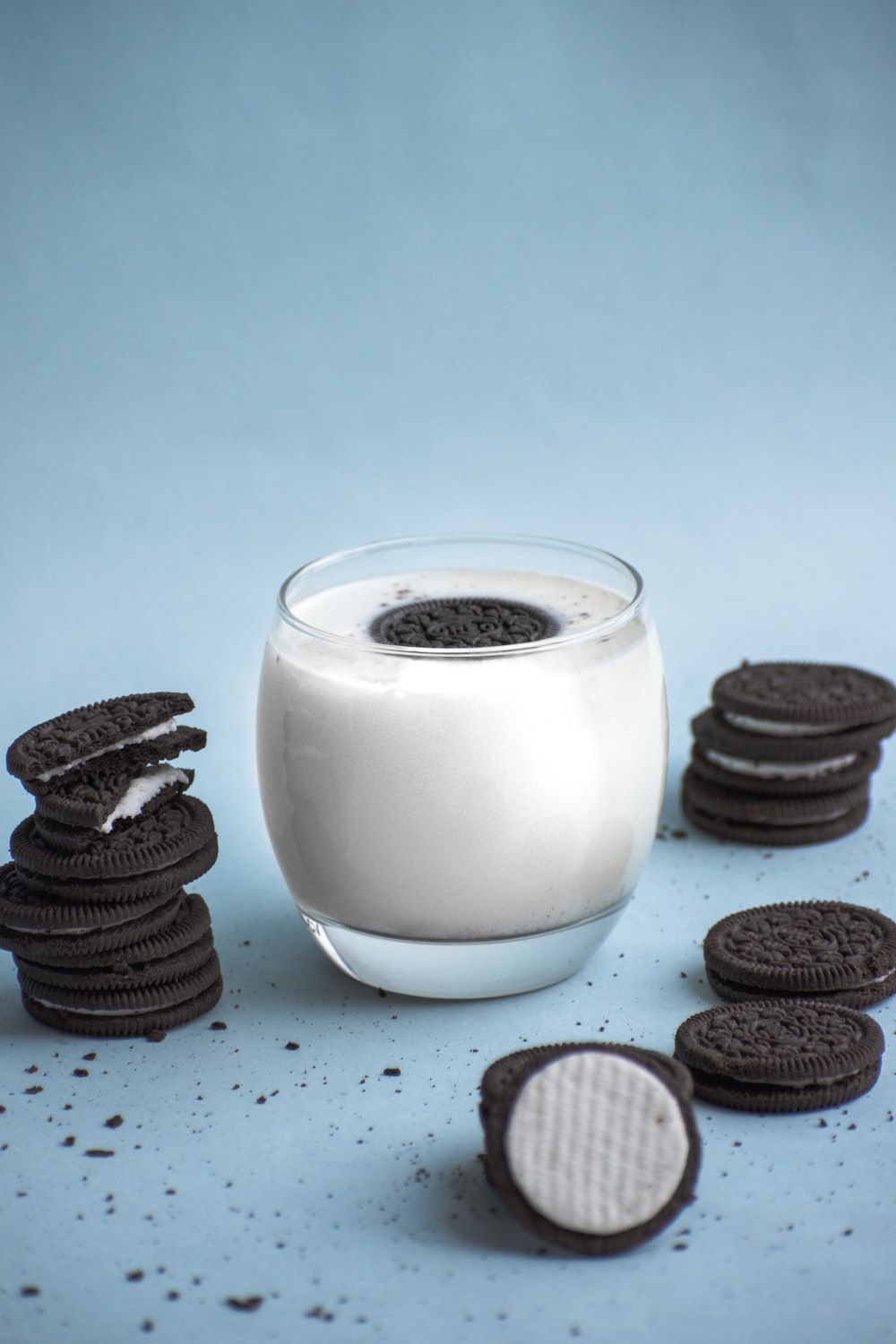 A glass of milk with cookies on the side - Oreo