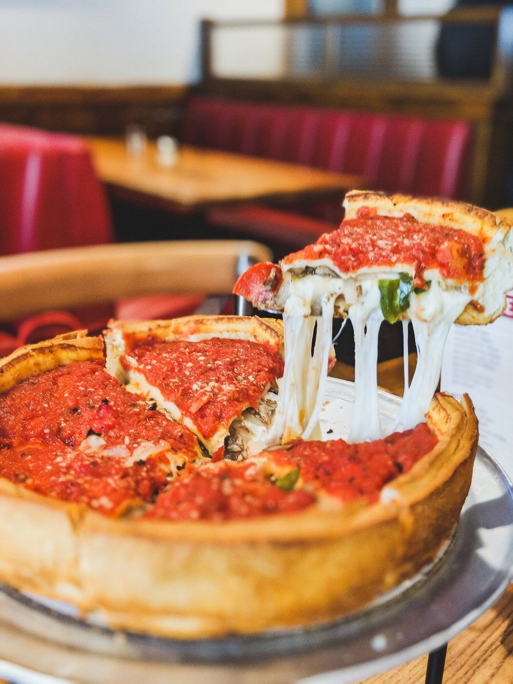 A deep dish pizza is being served - Pizza
