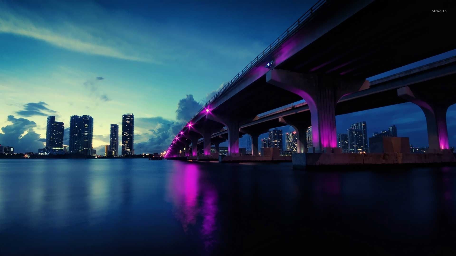 A bridge with purple lights over it at night - Miami