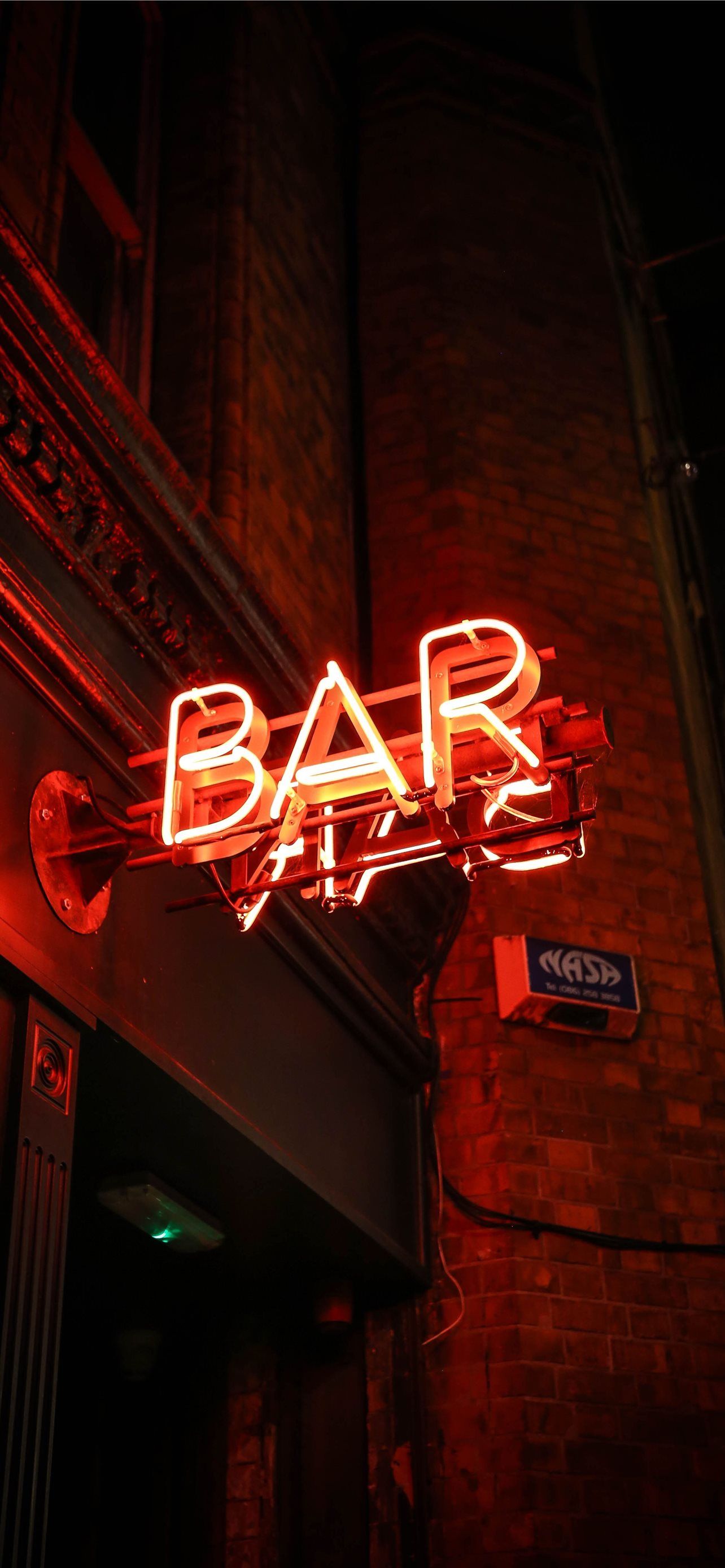 A red neon sign that says Bar on a brick wall. - Light red, iPhone red