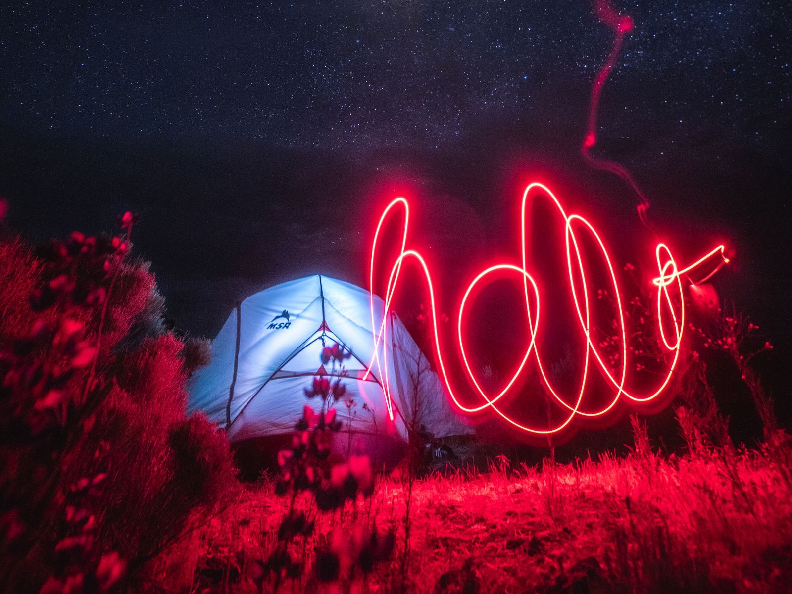A tent with the word hello written in neon - Light red, neon red