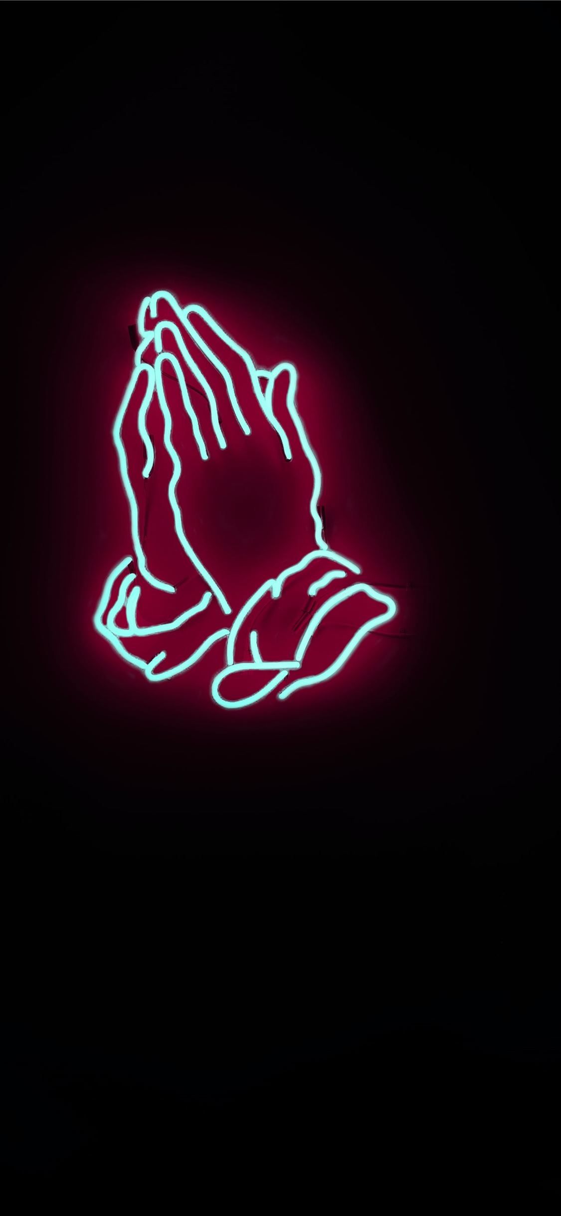 A neon sign of praying hands - 