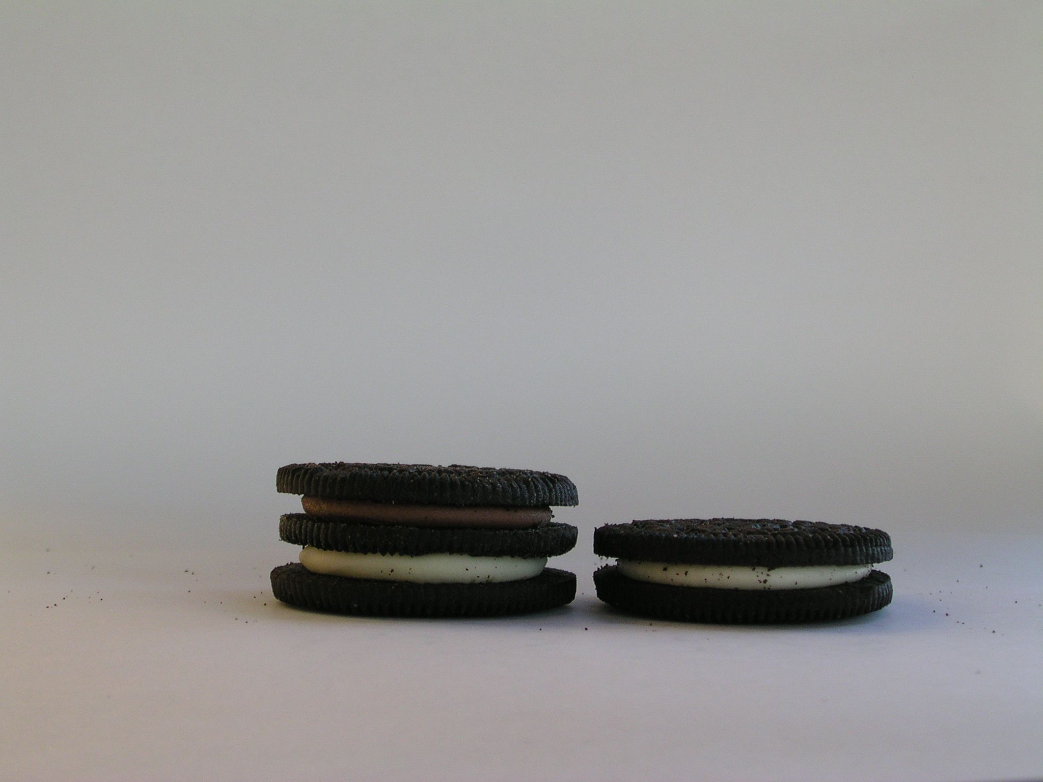 A white background with two stacks of oreo cookies. - Oreo