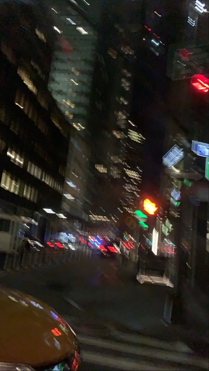 A blurry image of a city street at night with cars and traffic lights. - Blurry