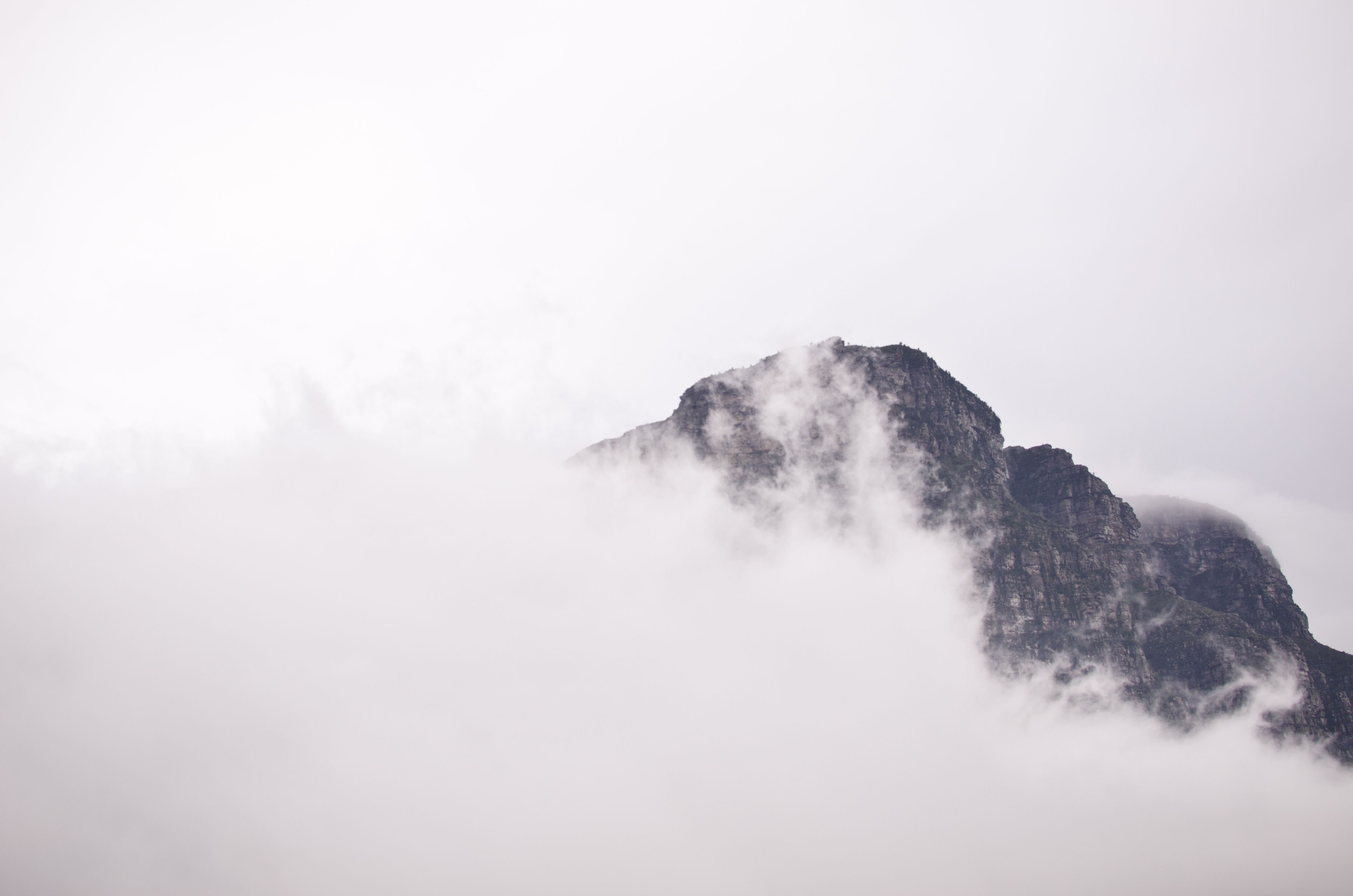 A mountain with clouds and fog in the background - Clean